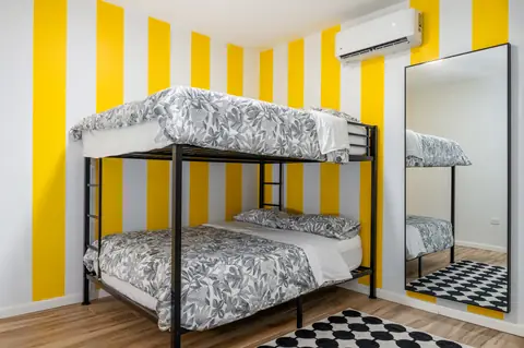 Bunk bedroom with yellow stripes — Casa Paraíso vacation rental in Isabela, Puerto Rico