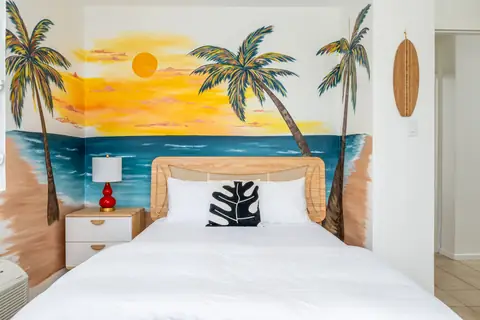 Bedroom with palm-beach sunset mural — Penthouse Vista Del Mar oceanfront rental in Isabela, Puerto Rico