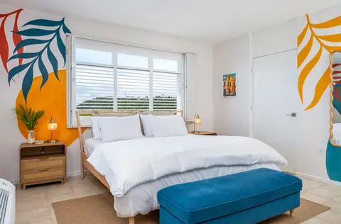 Bedroom with tropical leaf mural and ocean view — Penthouse Vista Del Mar oceanfront rental in Isabela, Puerto Rico